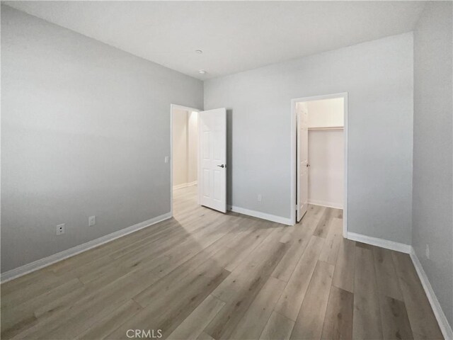 5393 Viewstone Ct, Hemet, CA 92545 - unfurnished bedroom with wood finished floors, a walk in closet, and baseboards