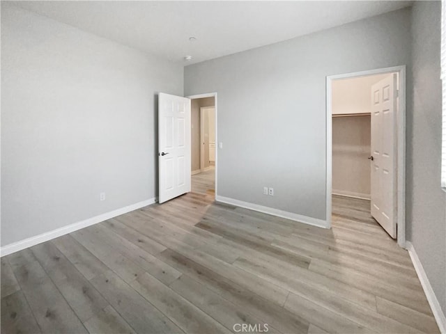 5393 Viewstone Ct, Hemet, CA 92545 - unfurnished bedroom with light wood-style flooring, a spacious closet, baseboards, and a closet