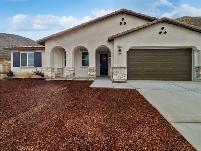 5393 Viewstone Ct, Hemet, CA 92545 - mediterranean / spanish house with stucco siding, concrete driveway, an attached garage, and a tiled roof