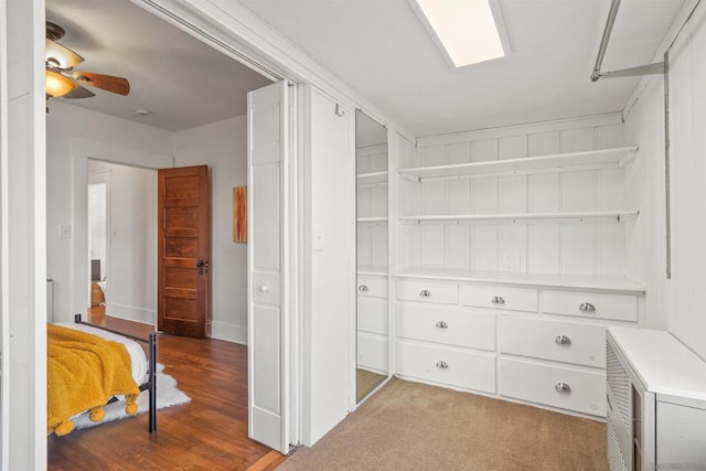 walk in closet featuring light colored carpet and ceiling fan