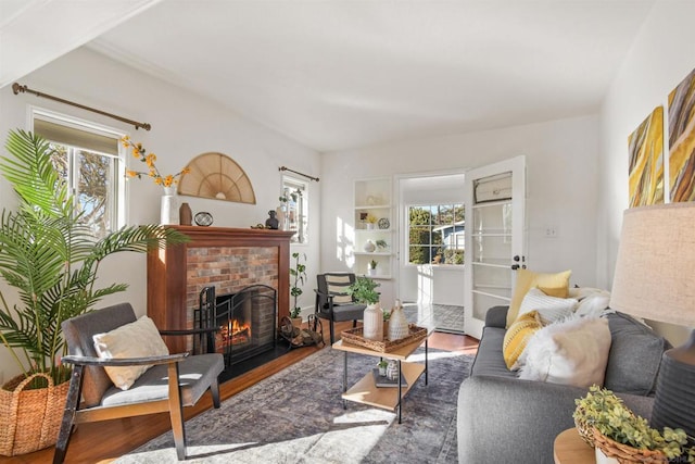 living room with hardwood / wood-style flooring, plenty of natural light, and a brick fireplace