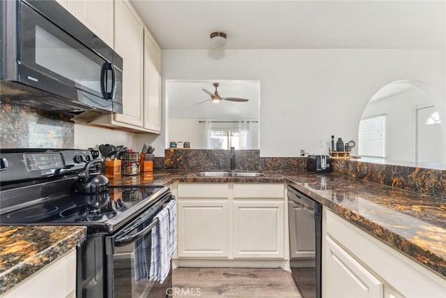 kitchen featuring white cabinetry, sink, black appliances, and dark stone countertops