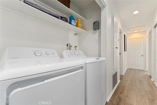 laundry room featuring independent washer and dryer and light hardwood / wood-style flooring