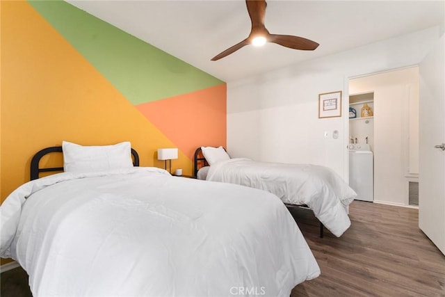 bedroom with washer / dryer, dark wood-type flooring, and ceiling fan