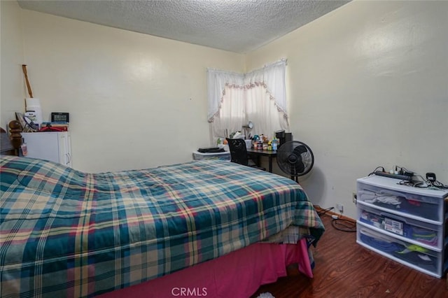 bedroom with dark wood-type flooring and a textured ceiling