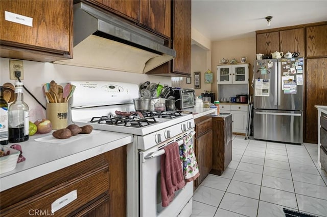 kitchen featuring stainless steel fridge and white gas stove