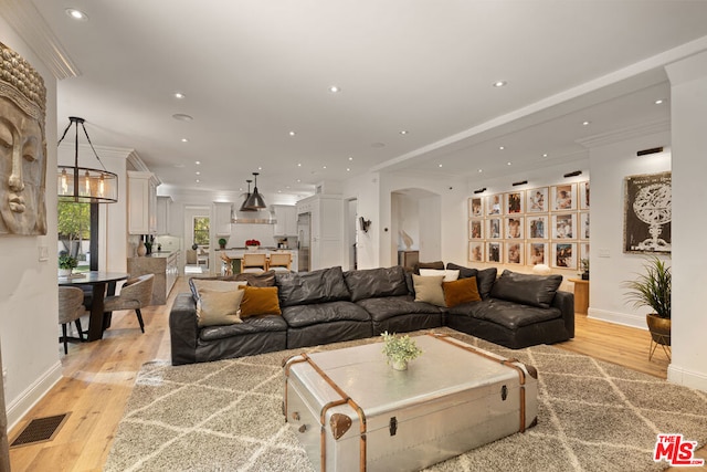 living room featuring crown molding and light hardwood / wood-style floors