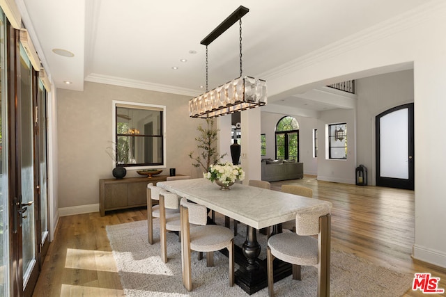 dining area with hardwood / wood-style flooring, ornamental molding, and french doors