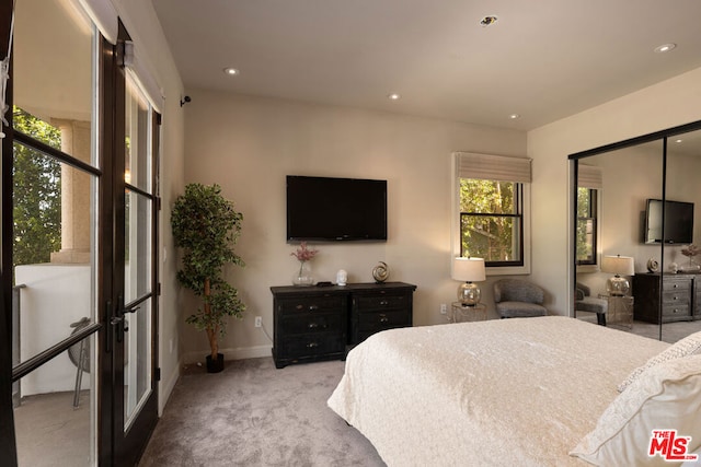 bedroom featuring french doors and light colored carpet