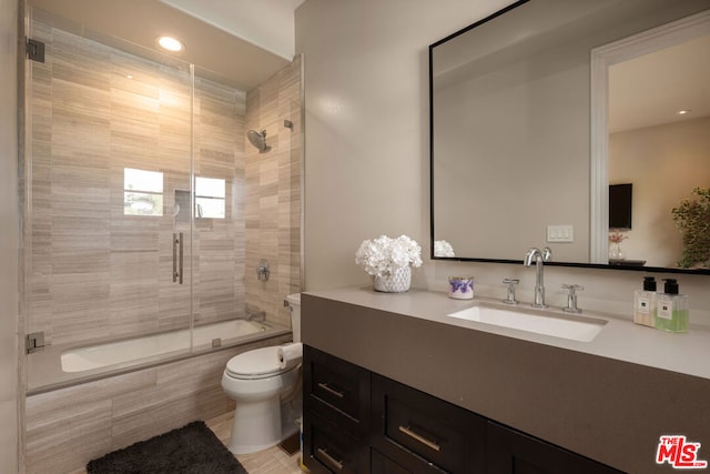 full bathroom featuring vanity, shower / bath combination with glass door, and toilet