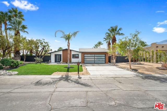 view of front of home with a garage and a front lawn