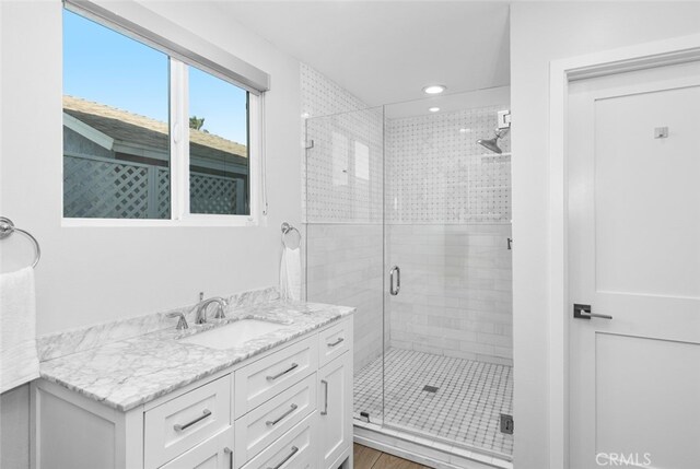 bathroom featuring vanity and a shower with door