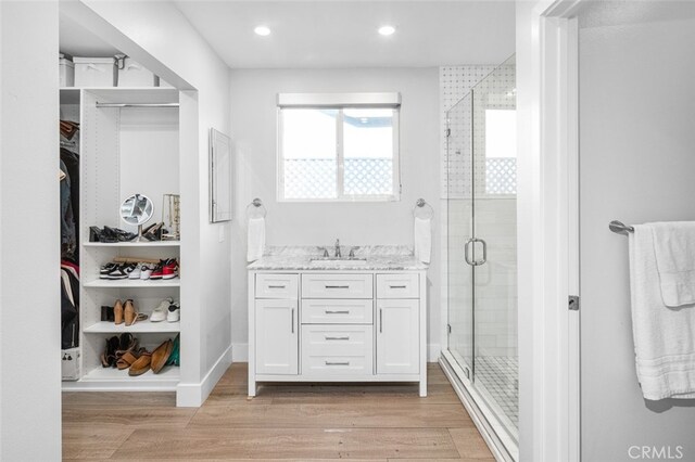 bathroom with vanity, wood-type flooring, and a shower with shower door