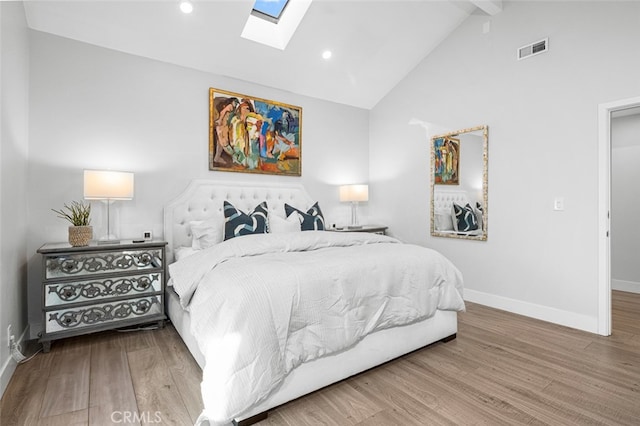 bedroom featuring beamed ceiling, wood-type flooring, a skylight, and high vaulted ceiling