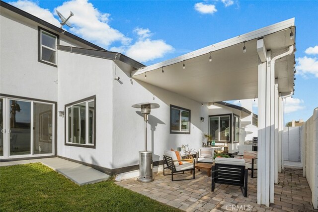 back of house with an outdoor living space and a patio