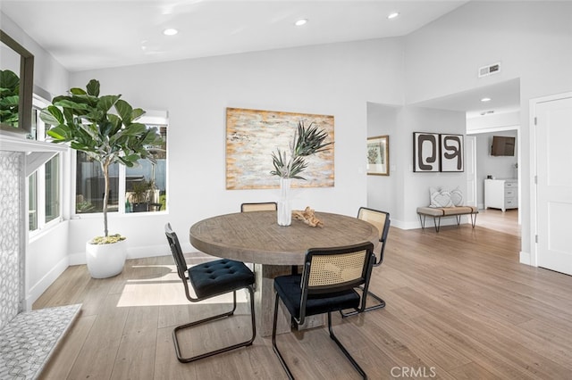 dining room with vaulted ceiling and light wood-type flooring