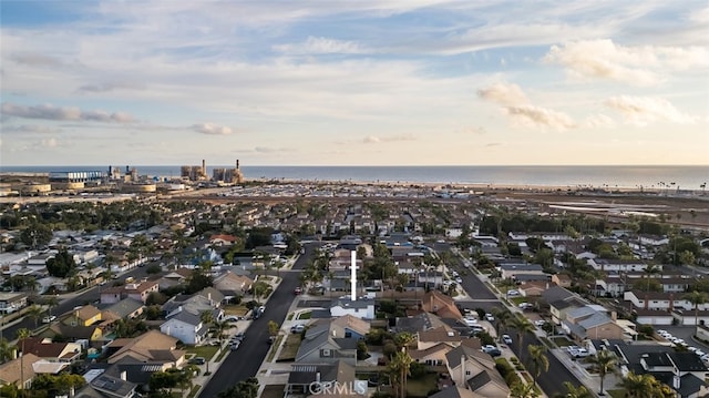 aerial view at dusk featuring a water view