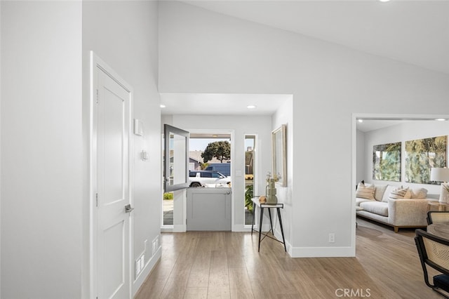 entryway featuring high vaulted ceiling and light wood-type flooring