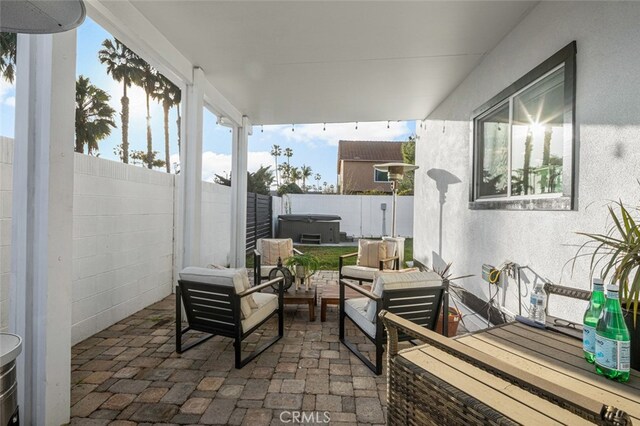 view of patio / terrace with a hot tub and an outdoor hangout area