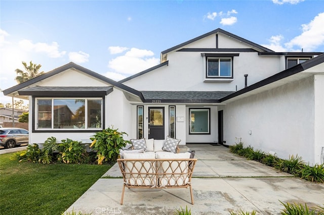 rear view of house with a yard and an outdoor hangout area