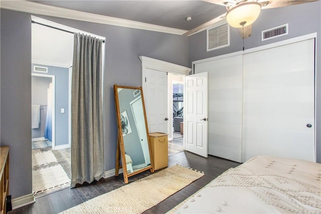 bedroom featuring crown molding, dark hardwood / wood-style floors, and a closet