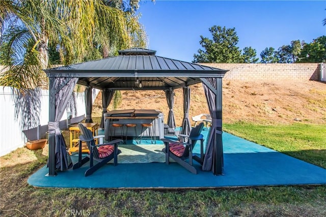 view of patio / terrace featuring a hot tub and a gazebo