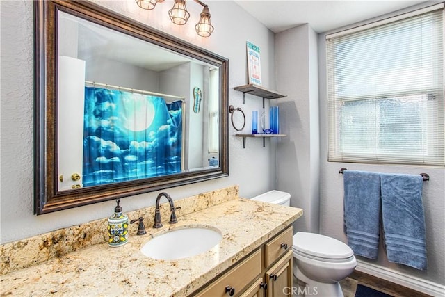 bathroom featuring a shower with curtain, vanity, and toilet