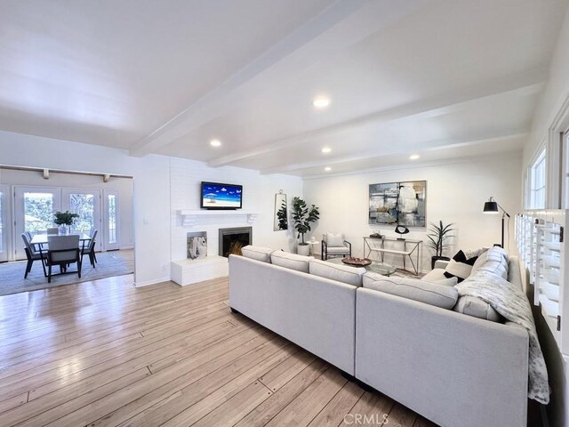 living room featuring beam ceiling and light hardwood / wood-style floors