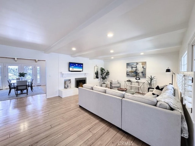 living room featuring beamed ceiling and light wood-type flooring