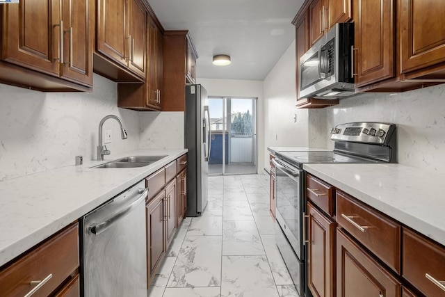 kitchen with light stone counters, sink, and appliances with stainless steel finishes