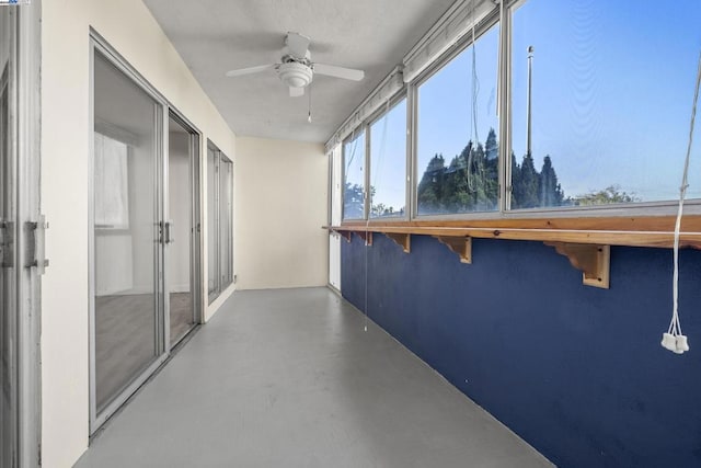 unfurnished sunroom with ceiling fan