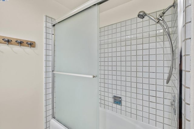 bathroom with bath / shower combo with glass door