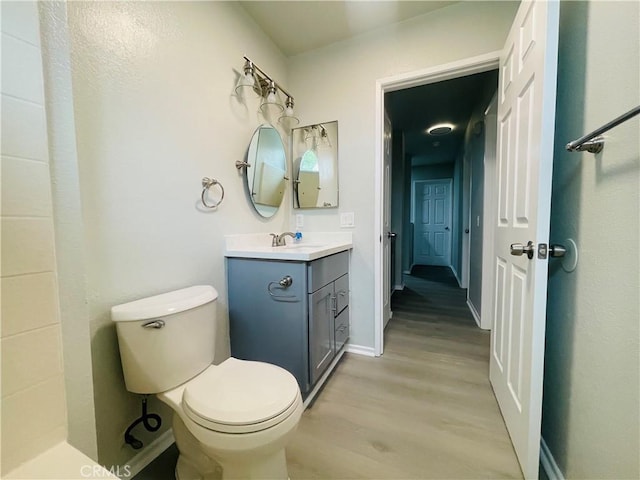 bathroom with vanity, toilet, and hardwood / wood-style floors