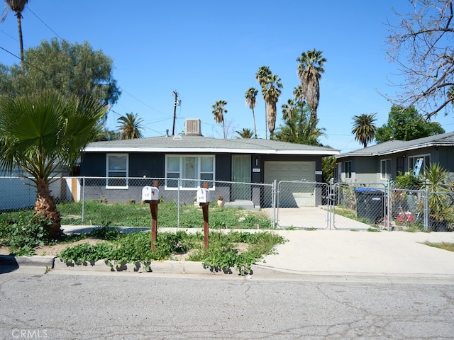 view of front facade featuring driveway, a gate, an attached garage, and a fenced front yard