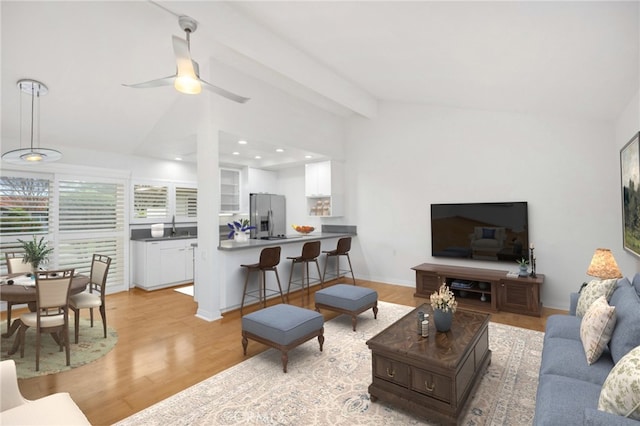 living room featuring vaulted ceiling, sink, ceiling fan, and light hardwood / wood-style flooring