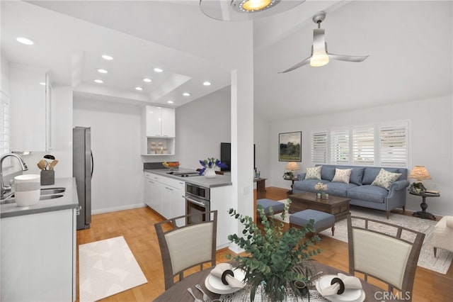 dining room with ceiling fan, sink, and light hardwood / wood-style flooring