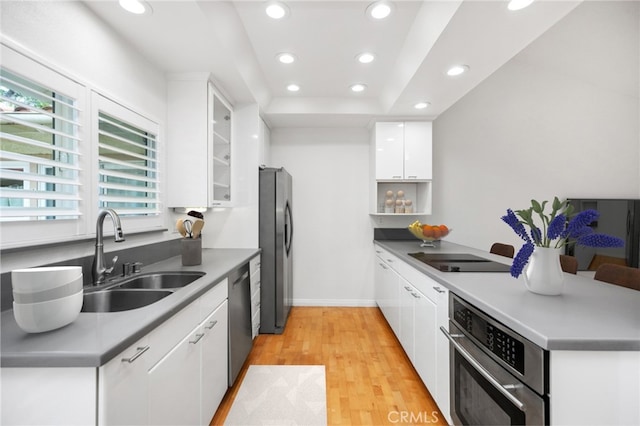 kitchen featuring light wood-type flooring, stainless steel appliances, sink, and white cabinets