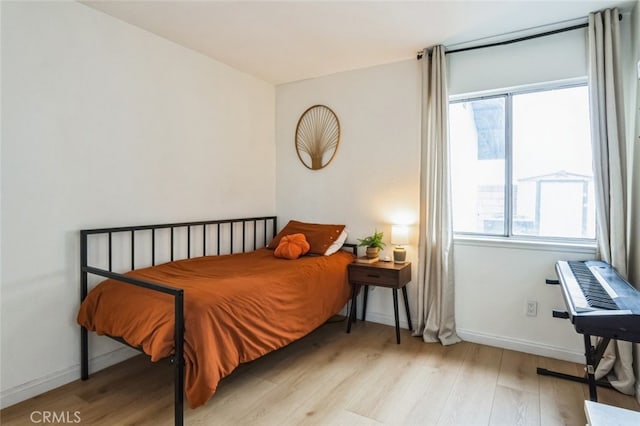 bedroom with baseboards and light wood finished floors