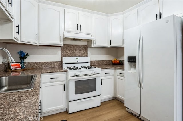 kitchen with white appliances, white cabinets, under cabinet range hood, and a sink