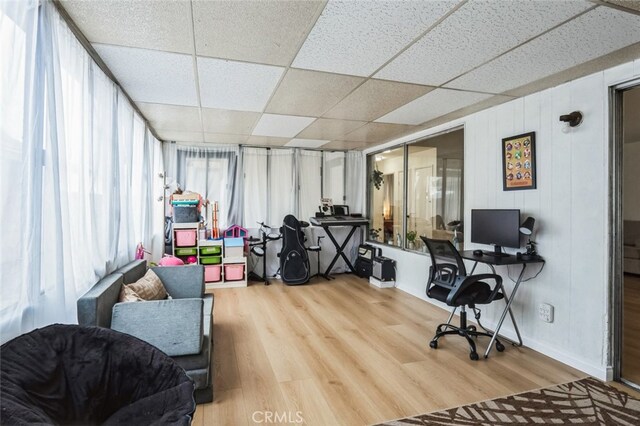 office space with a paneled ceiling and light hardwood / wood-style floors