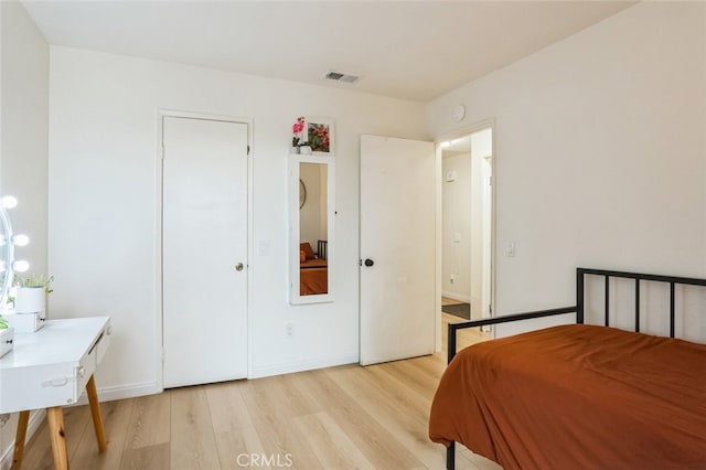 bedroom featuring light wood-type flooring, visible vents, and baseboards