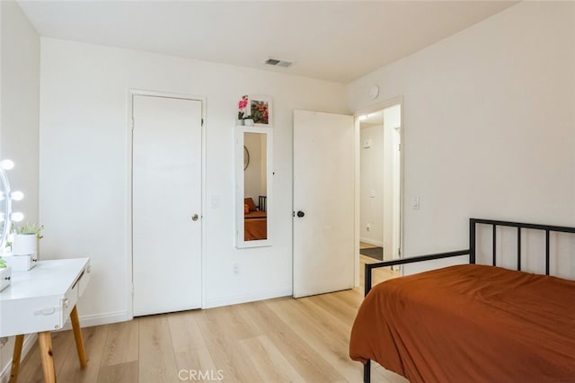 bedroom with light wood-type flooring and visible vents