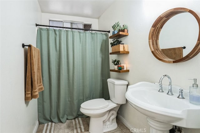 bathroom with a sink, toilet, tile patterned floors, baseboards, and a shower with curtain