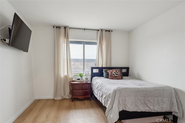 bedroom with baseboards and light wood-type flooring