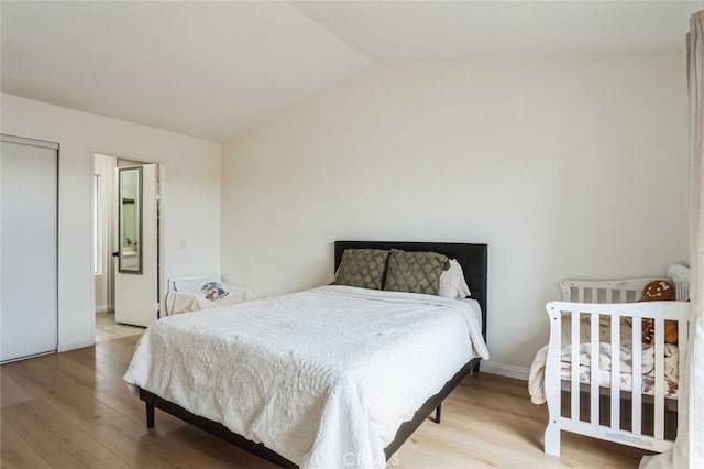 bedroom with vaulted ceiling and wood finished floors