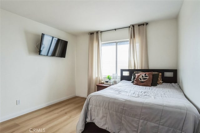 bedroom featuring wood finished floors and baseboards