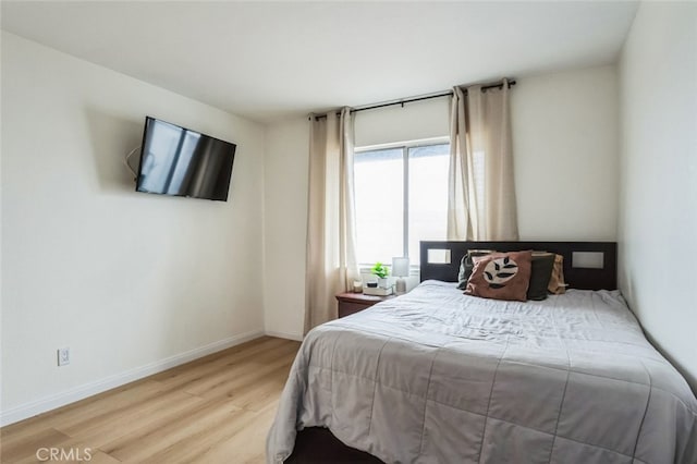 bedroom with baseboards and light wood-style flooring
