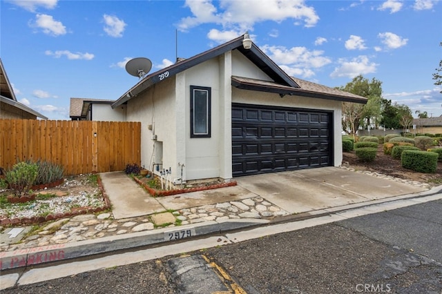 2979 Cardamon St, Rialto, CA 92376 - view of home's exterior featuring fence, stucco siding, a garage, and driveway