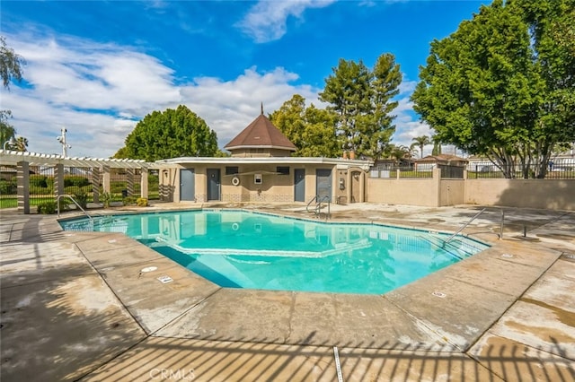 pool with fence, a pergola, and a patio