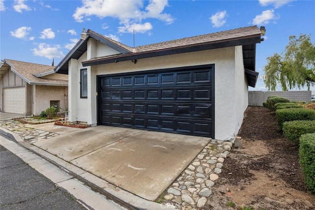 view of front of house featuring an attached garage, driveway, and stucco siding